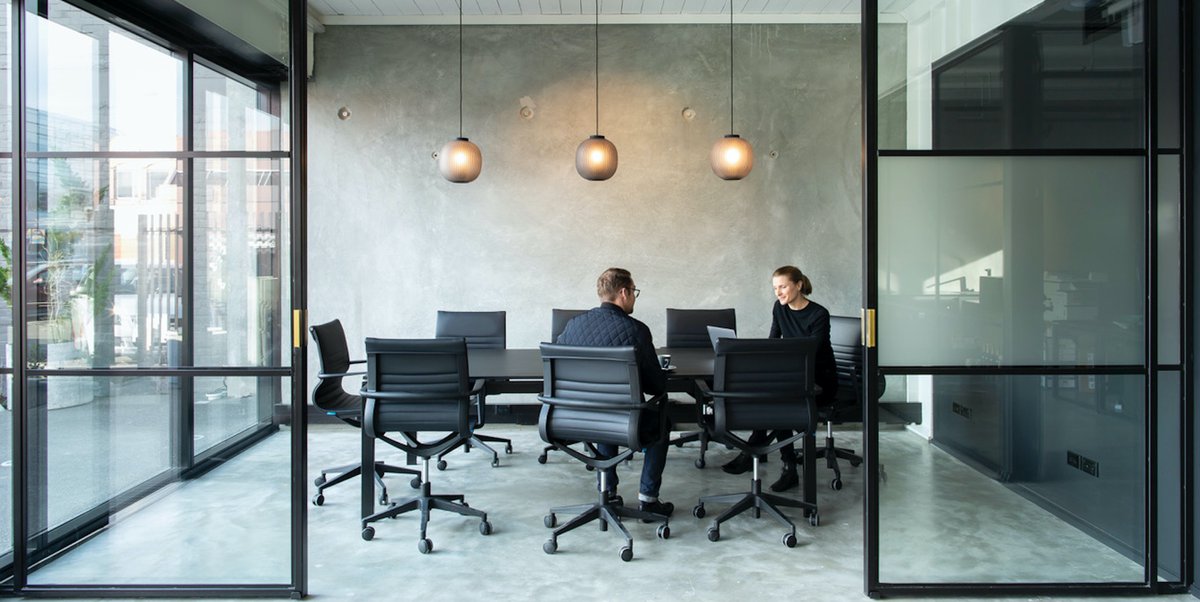 Two people conversing in meeting space